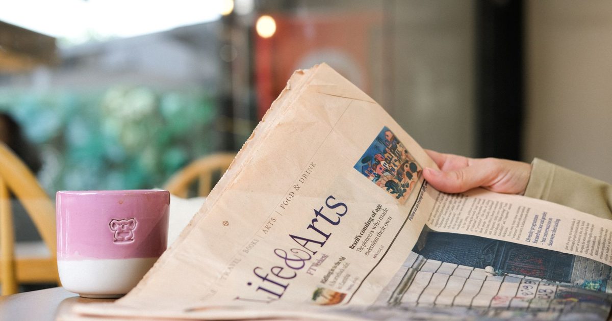 Filiżanka kawy i gazeta - komunikat prasowy małej firmy