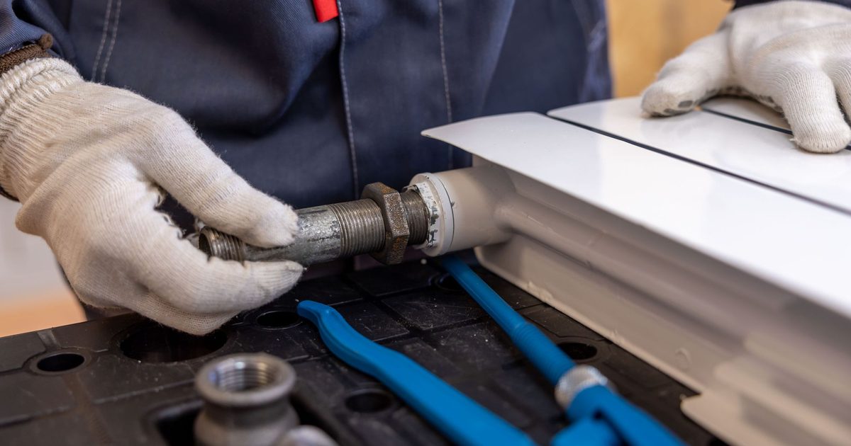 Plumber working on a combi boiler in a UK kitchen - websites for plumbers