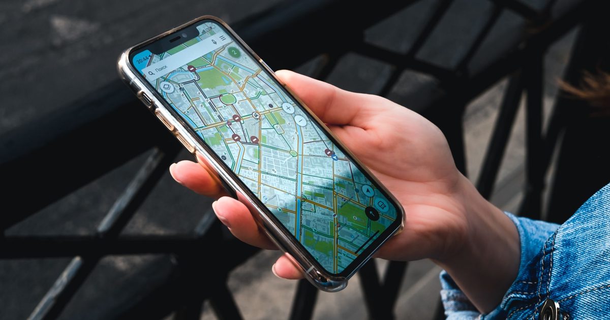 Ręka trzyma smartfon z mapą - skąd AI bierze dane o lokalnych firmach