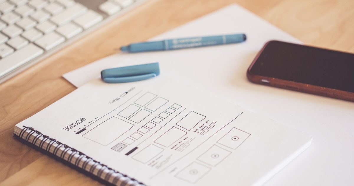 Designer's desk with before-and-after website layouts on screen - website redesign cost UK