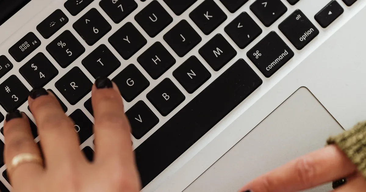 Dłonie piszące na klawiaturze laptopa - codzienna praca z treściami